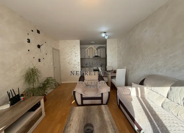 Living room with sofa set and dining area in the background.