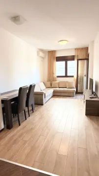 Prostrana dnevna soba sa garniturom za sedenje, trpezarijskim stolom i televizorom. - image 4