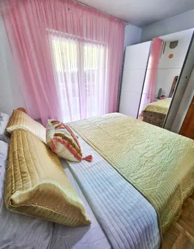 Furnished bedroom with a large double bed, wardrobe, and pink curtains. - image 12