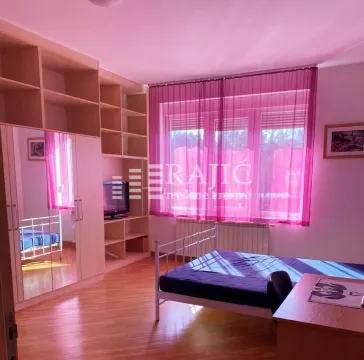 Furnished bedroom with a bed, wardrobe, and desk. - image 4