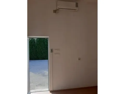 An empty room with an air conditioner and a view through an open doorway. - image 4