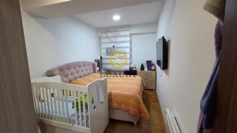 Spavaća soba sa bračnim krevetom, krevetcem za bebe i televizorom na zidu. - image 8
