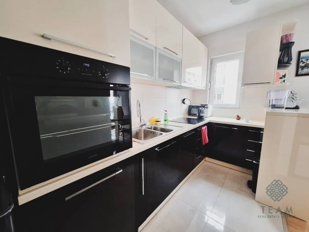 Compact kitchen with built-in cabinetry and appliances.