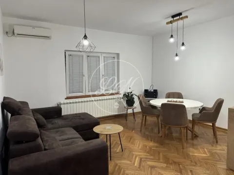 Living room with a sofa, dining table, and parquet flooring. - image 3