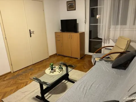 Living room with a sofa, coffee table, and television. - image 4