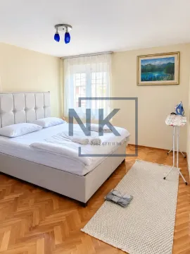 Furnished bedroom with a double bed, window, and parquet flooring. - image 2