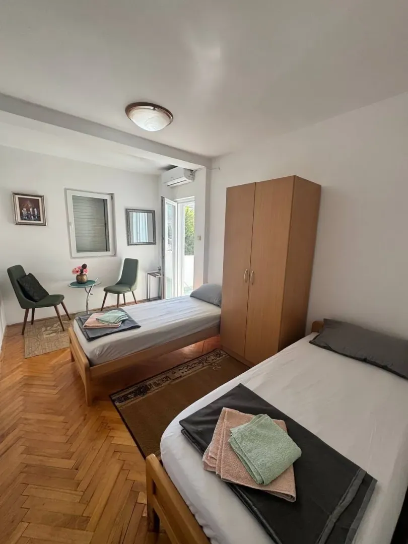 Furnished bedroom with two single beds and a wardrobe.