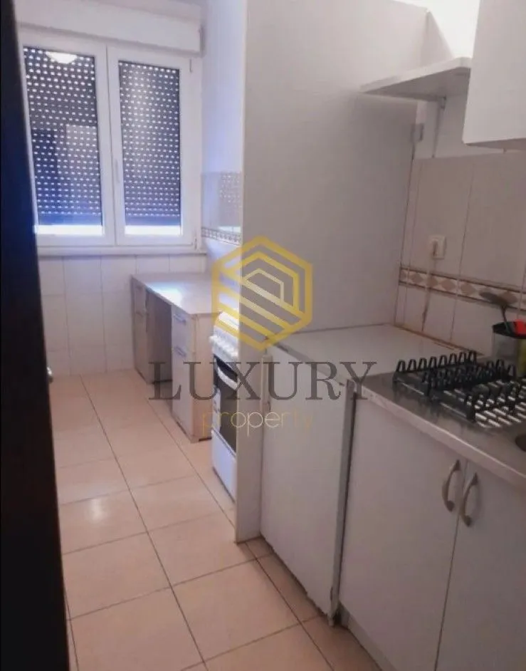 Small bright kitchen with basic elements and a stove.