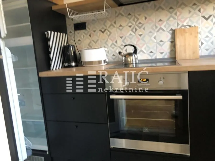 Modern kitchen with black cabinetry and a built-in oven.