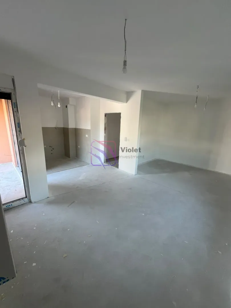 Neopremljen enterijer u fazi izgradnje sa bijelim zidovima i betonskim podom.