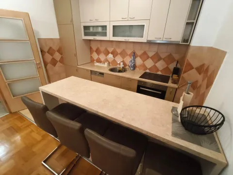 Kitchen equipped with cabinetry featuring a breakfast bar and dining chairs. - image 7