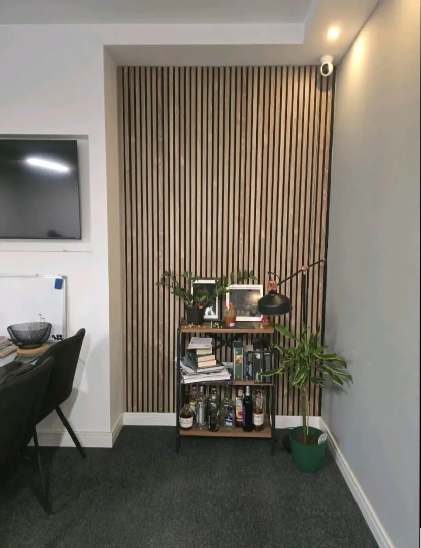 Part of a living room with wooden wall panels and a bookshelf.