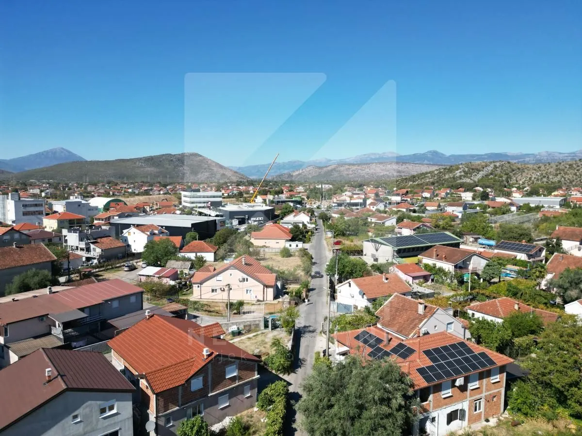 Pogled iz ptičje perspektive na naselje i okolne planine.