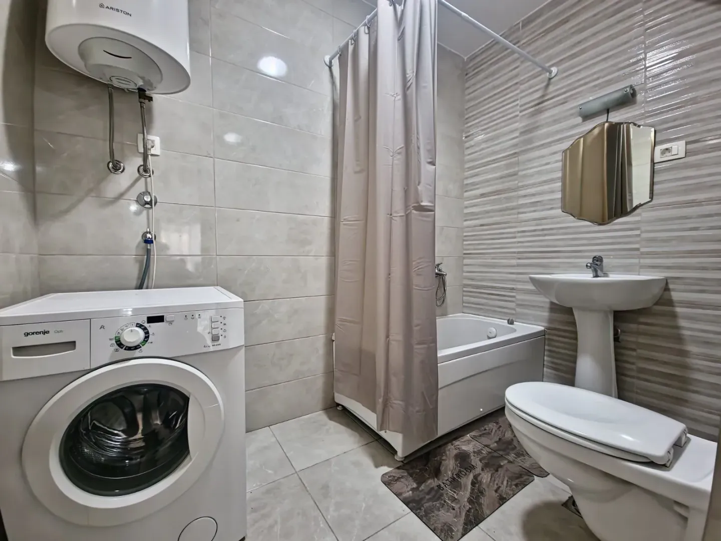 Bathroom equipped with a shower, washbasin, toilet, and washing machine.