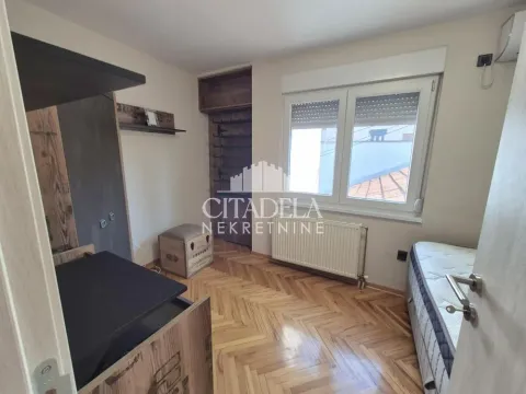 Manja spavaća soba sa krevetom, prozorom i drvenim podom. - image 8