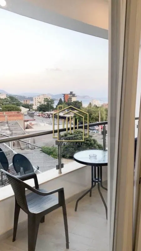 A small furnished balcony with a view of the neighborhood and the sea.