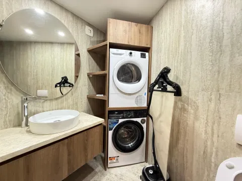 Moderno kupatilo sa umivaonikom, ogledalom i ugrađenim mašinama za pranje i sušenje veša. - image 12