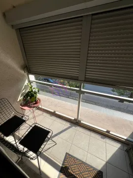 Manji namješten balkon sa staklenom ogradom i roletnama na prozorima. - image 16