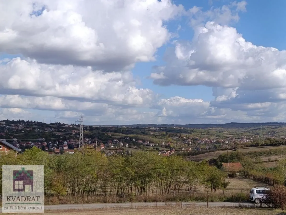Pogled na okolno naselje i prirodu sa oblačnim nebom.