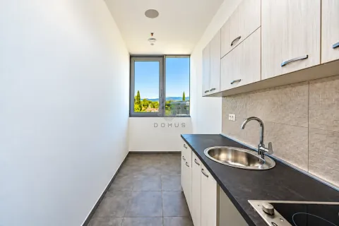 Small kitchen with a sink, built-in cabinets, and a window with a view of nature. - image 12