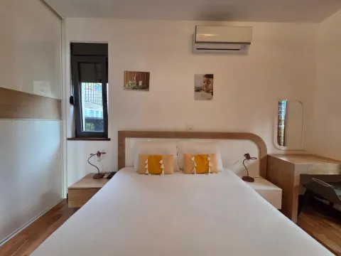 Bright bedroom with a double bed, wardrobe, and air conditioning. - image 11