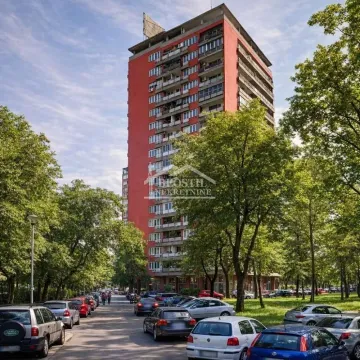 Pogled na spoljašnjost stambene zgrade sa zelenilom i parkingom u okolini. - image 14
