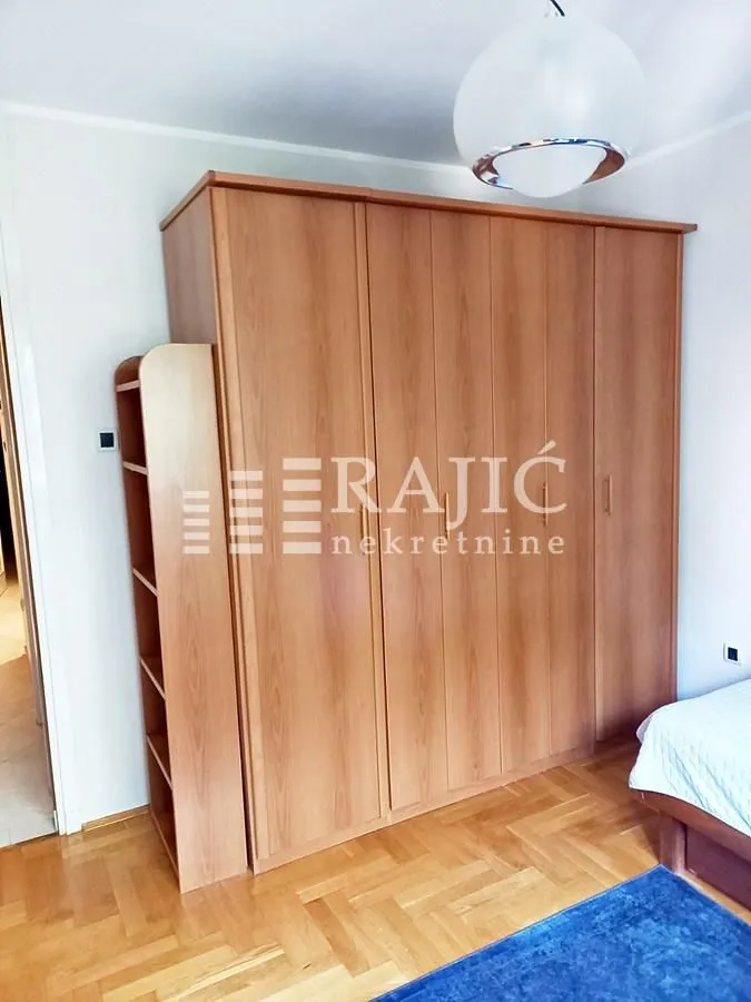 Bedroom with a large wooden wardrobe and a bed.