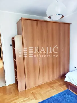 Bedroom with a large wooden wardrobe and a bed. - image 13