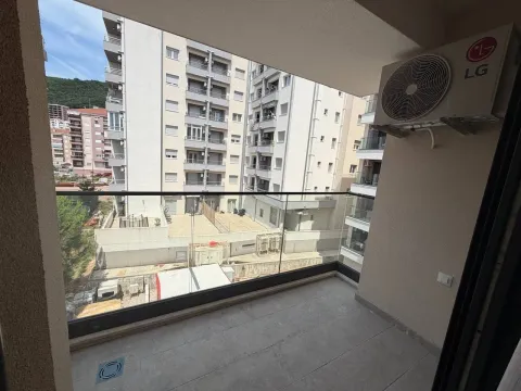 Natkriveni balkon sa staklenom ogradom i pogledom na okolne zgrade. - image 8