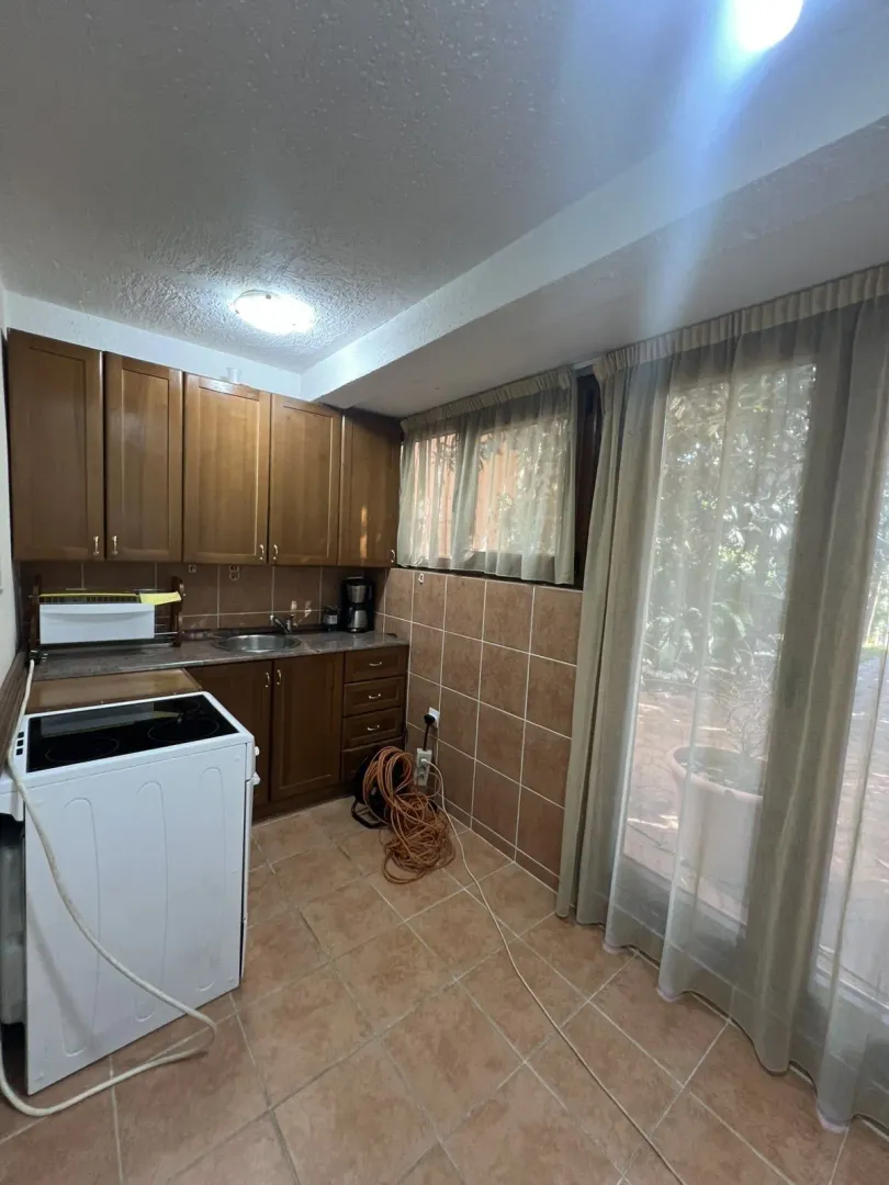 A small kitchen featuring wooden cabinets and tiled flooring.