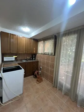 A small kitchen featuring wooden cabinets and tiled flooring. - image 5