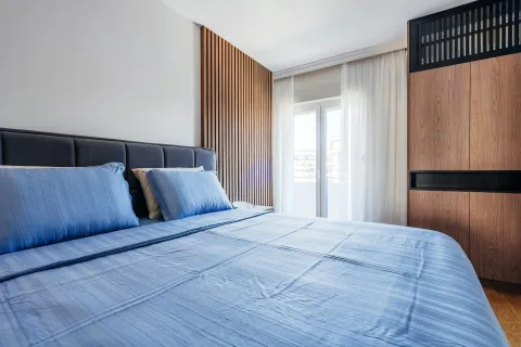 Modern bedroom with a double bed, wooden wall panel, and built-in wardrobe. - image 7