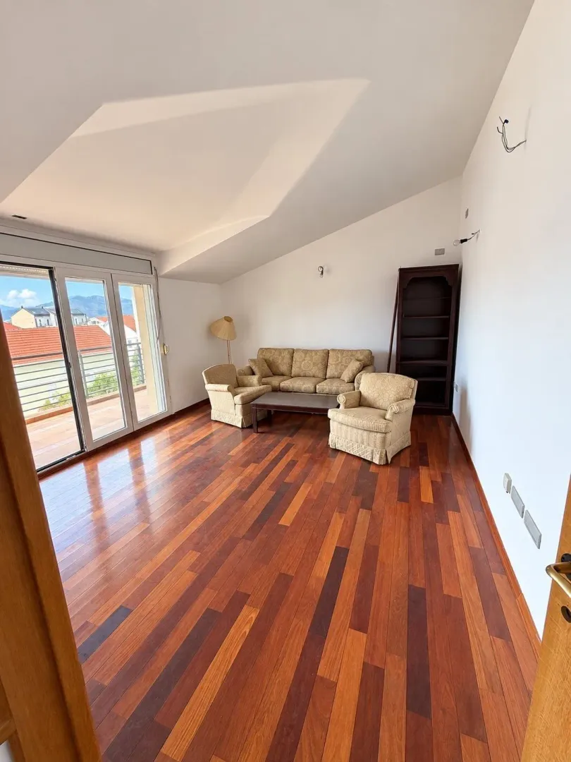 Spacious living room with sofa set and wooden floor.