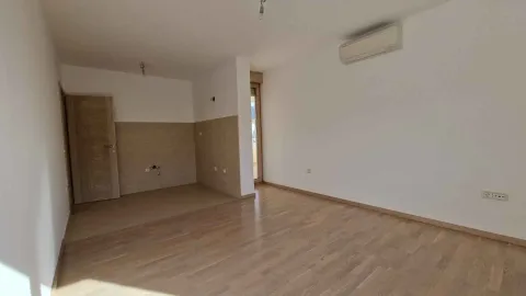 Prazna dnevna soba sa parketom i kuhinjskim dijelom u pozadini. - image 4