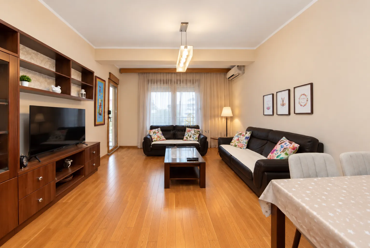 Spacious living room with seating furniture, TV unit and dining table.