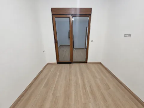Prazna soba sa laminatom i balkonskim vratima. - image 3