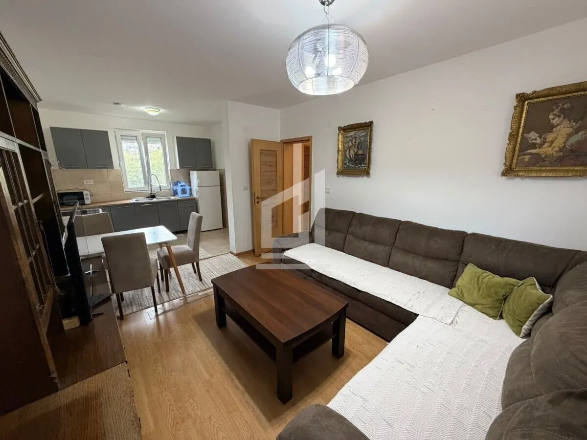 Living room with a sofa, coffee table, and adjoining dining area.