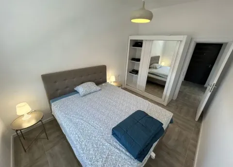 Furnished bedroom with a double bed, wardrobe, and nightstands. - image 4