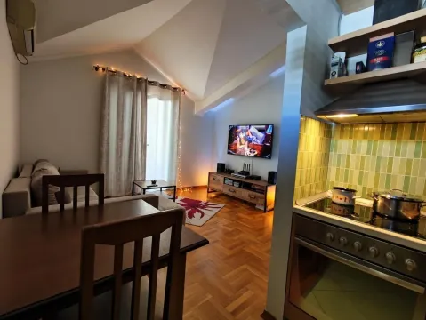 View from the kitchen towards the living room and dining area with wooden flooring. - image 14