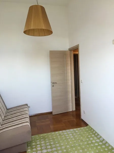 Bright living room with a sofa and parquet flooring.