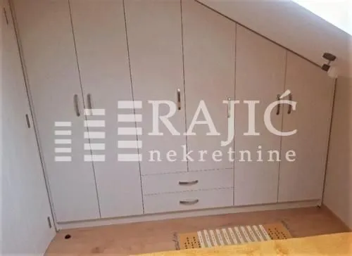 Bedroom with a fitted wardrobe adapted to the roof slope.