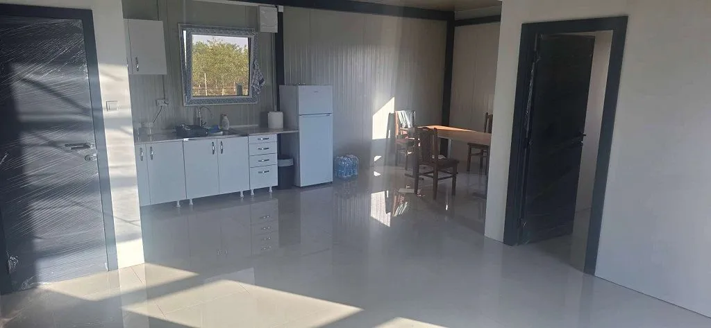 Spacious bright room with a kitchen and dining area.