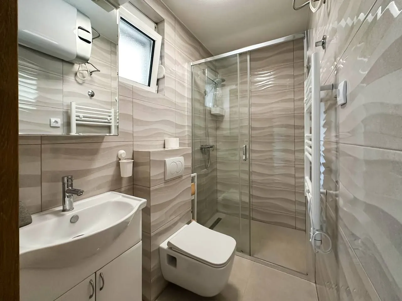Modern bathroom with a glass shower cabin and a sink.