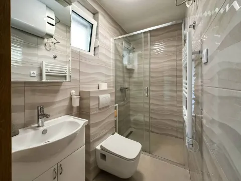 Modern bathroom with a glass shower cabin and a sink. - image 9
