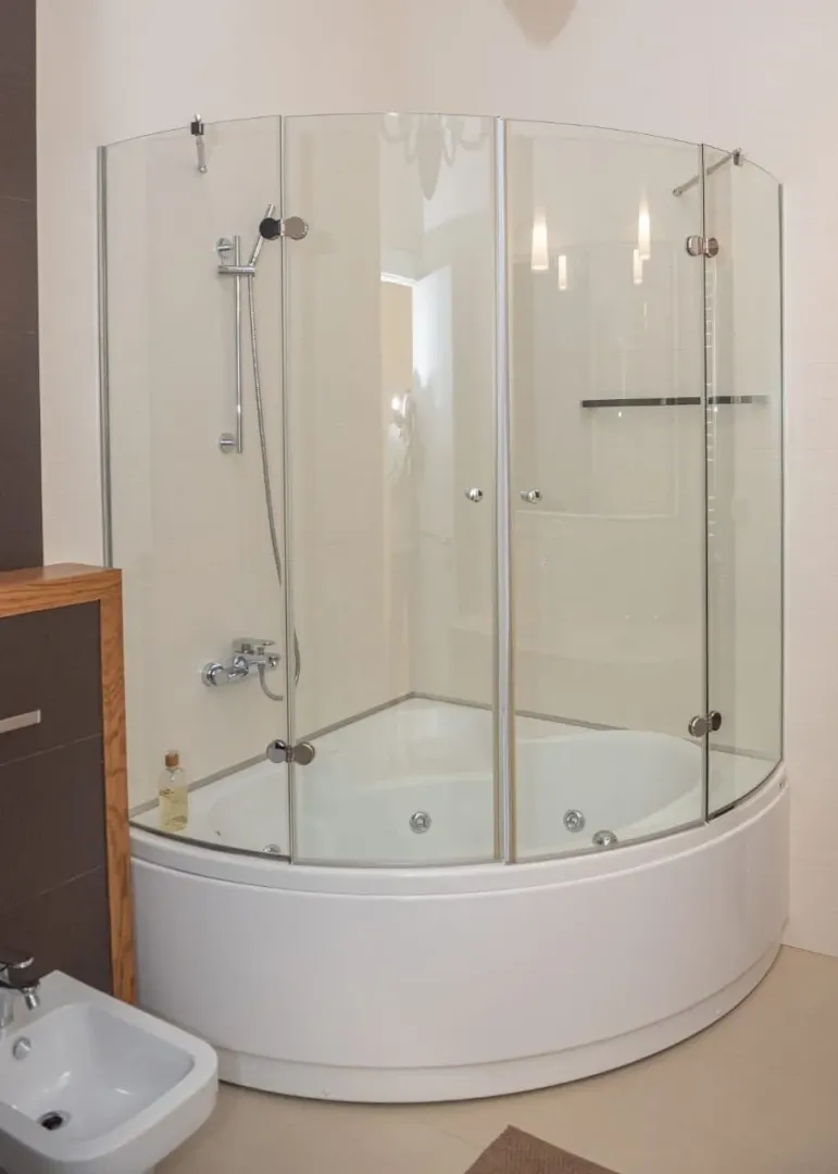 Modern bathroom with a corner shower cabin and hydromassage bathtub.