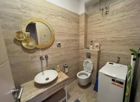 Moderne kupatilo sa umivaonikom, WC šoljom i veš mašinom obloženo bež pločicama. - image 9