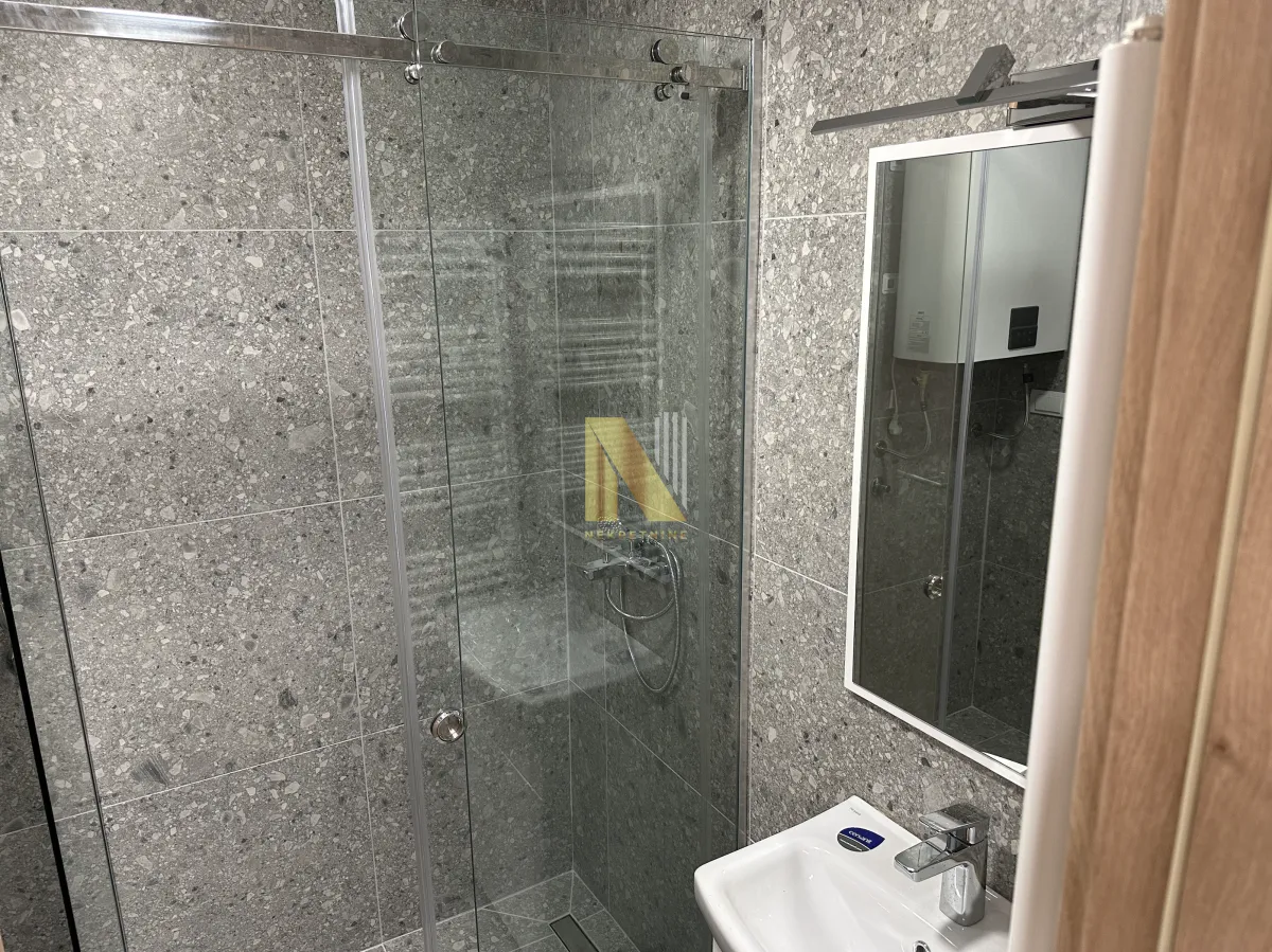 Modernly equipped bathroom with a shower cabin and a washbasin.