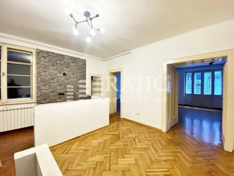 Living room with parquet flooring and a decorative stone wall. - image 4
