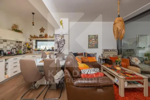 Otvoreni dnevni boravak sa trpezarijom i kuhinjom u toplim tonovima. - image 3