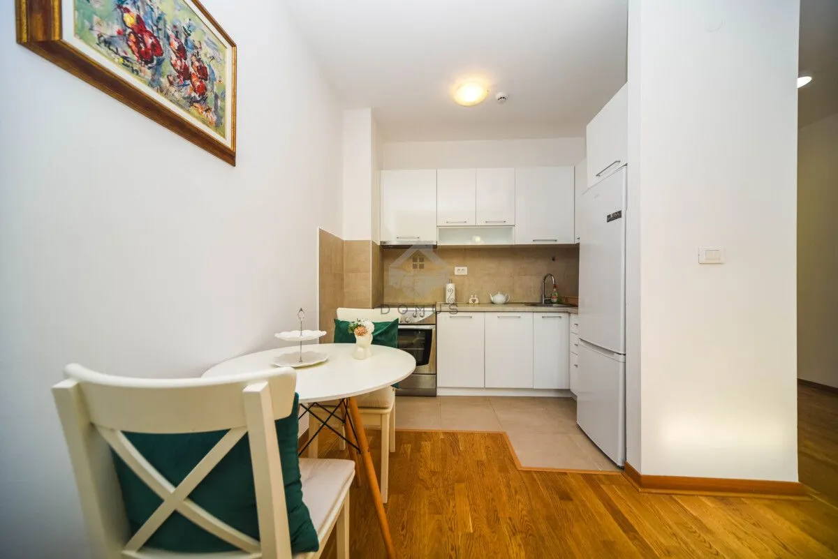 Smaller white kitchen with a dining table and chairs.